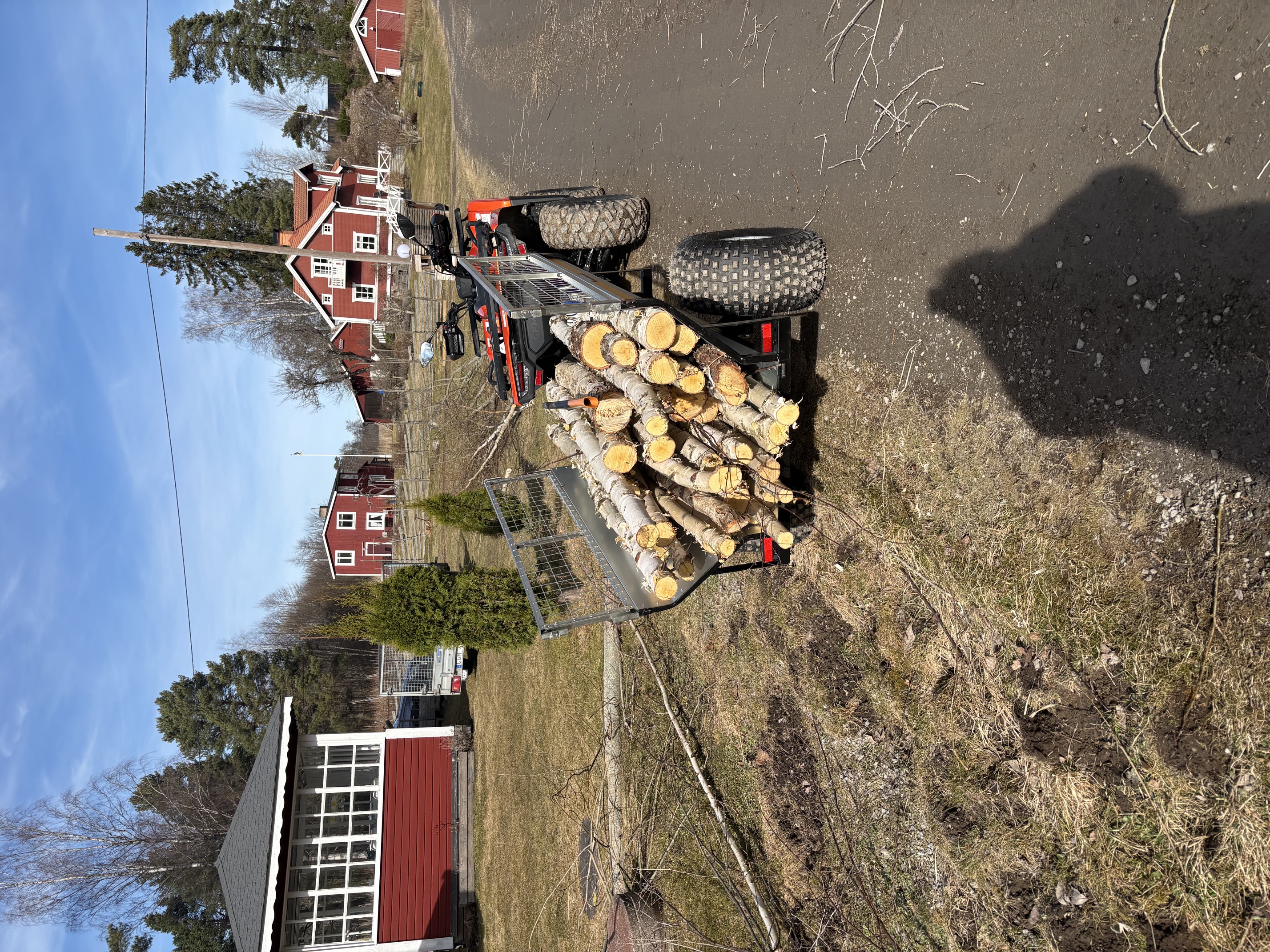 ATV and trailer hauling cut logs