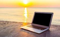 Laptop on a beach at sunset
